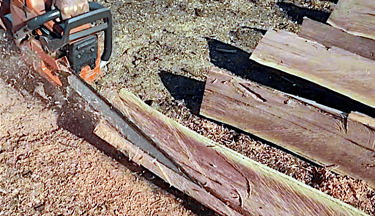 Facing fence post with chainsaw