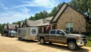 Trailer & work trucks after completion of a commercial roof replacement at a Tyler, TX condominium