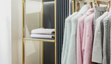 Organized closet with neatly arranged clothing (color coordinated) - home organizing.