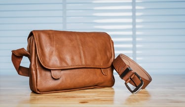 Vintage travelling for men's accessories, brown bag and belt put on modern wooden desk table in the office