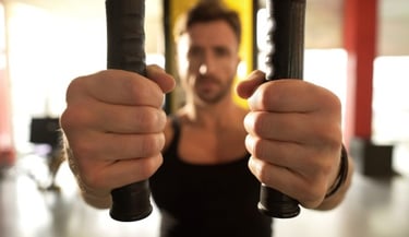 A man performs a chest fly workout on a cable machine at the gym for strength training.