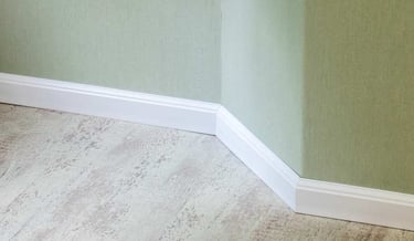 Baseboard trim covering the edge gap between wall and flooring.