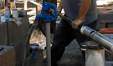 Technician installing new well pump down into well housing.