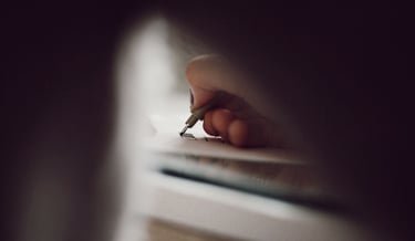 a person writing on a piece of paper
