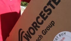 A Worcester Bosch Group cardboard product box held by a person wearing a red shirt.