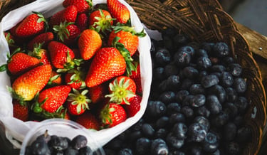 Fresh blueberries and strawberries in ceramic bowls as low-glycemic fruits for people with diabetes.