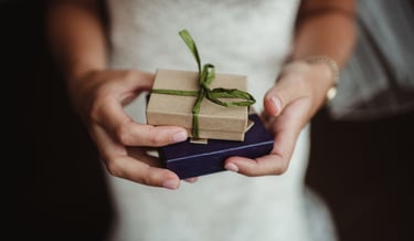Bride holding small gift boxes—wedding gift idea for video package
