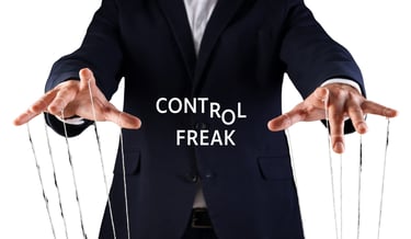 Businessman as a puppet master manipulating strings with Control Freak text overlay.