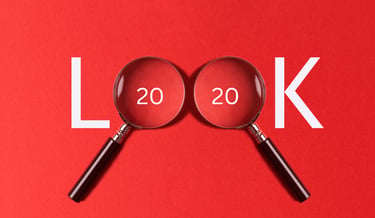 The word LOOK spelled with magnifying glasses over the zeros on a red background for 20/20 vision concept.