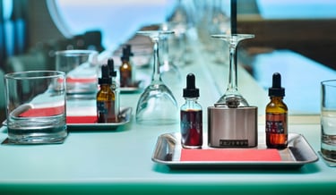 A craft cocktail kit with bourbon bitters and rich syrup bottles on a modern bar counter.