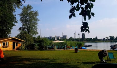 a person standing in a field with a boat in the background