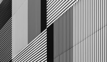 Abstract architectural facade with varying black and white stripes.