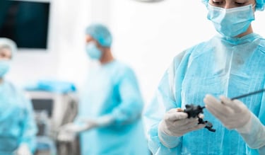 a woman in a blue gown and surgical equipment proceeding arthroscopy