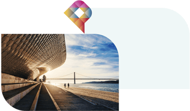 Arquitetura moderna à beira-mar em Lisboa com pessoas a caminhar ao longo do rio Tejo ao pôr-do-sol.