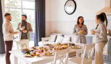a group of people standing around a table with food