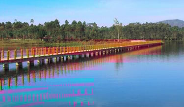 Jembatan gantung oranye di atas danau Situ Cileunca yang biru jernih dengan latar belakang hutan pinus dan langit biru cerah