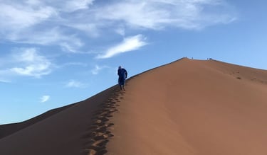 Visitor climbing Erg Zahar dune, Morocco, known as the ‘dune of whispers’