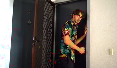 a man in a hawaiian shirt is standing in a doorway