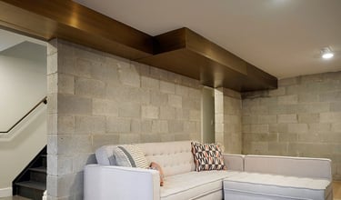 Home interior brass air vent above a couch, made by Pengelly Iron Works