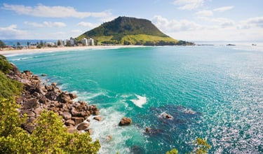 Vista do monte e do mar da Bay of Plenty em Tauranga, com a cidade ao fundo e céu claro.