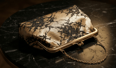 Close-up of black lace overlay on champagne gold satin clutch bag by King Fly.