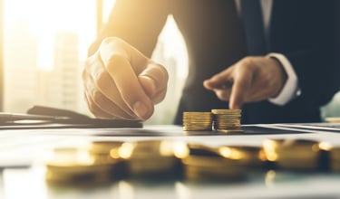 investment manager with gold coins and investing papers