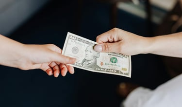 two people holding onto a dollar bill representing blog post about gold ira fees and a guide to understanding gold ira fees