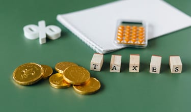 gold coins, calculator and word taxes show gold ira taxes and learning potential tax benefits