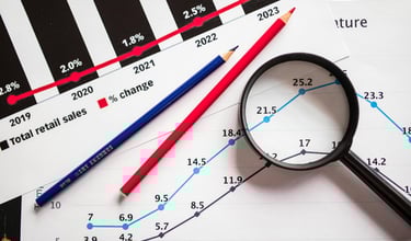 magnifying glass highlighting investing chart symbolizing gold market for precious metals