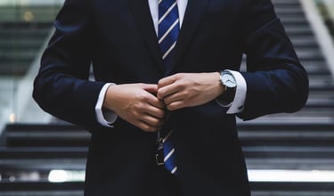 gold ira company worker with suit on in front of stairs representing choosing the right gold ira company