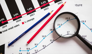 magnifying glass highlighting investing chart symbolizing gold market for precious metals