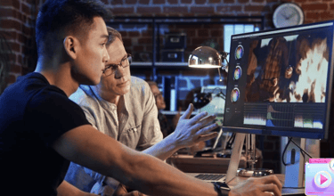 two men sitting at a computer screen and creating video with AI software