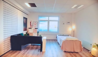 a room with a bed and a desk-Massage Raum Paderborn