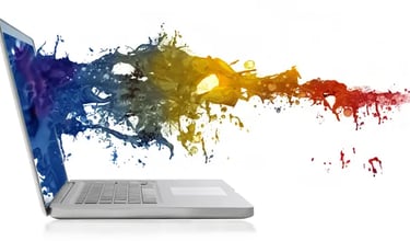 A laptop on a white background with a colorful splash of paint emerging from its screen.
