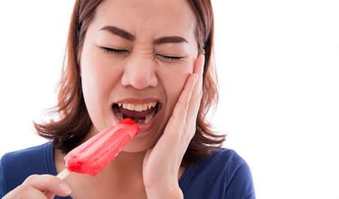 a woem biting ice experiencing tooth sensitivity