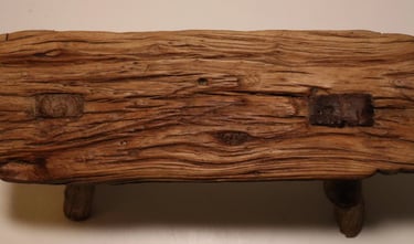 Extreme close-up of dark grained wood texture showing vertical lines and a curved cutout edge.