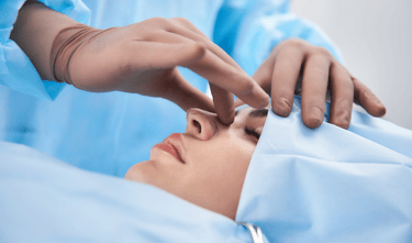 Surgeon performing a rhinoplasty procedure on a female patient in a medical clinic.