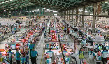 a factory floor with lots of people working on machines