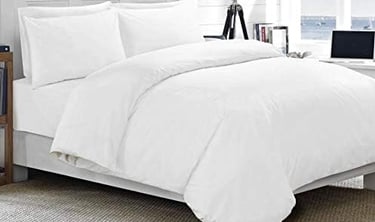 a bed with a laptop on top of it