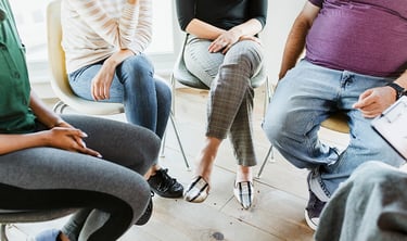 People sitting in a circle during a group therapy session.