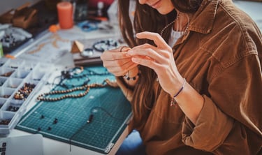 Artesana elabora un collar con técnica de macramé en su taller 
