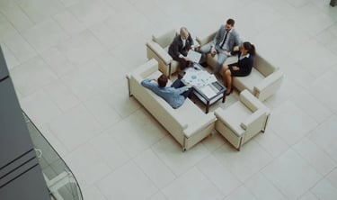 High angle view of diverse business colleagues in a formal meeting discussing data charts in a modern office lobby.