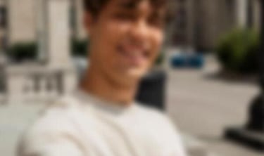 a sugar daddy in a white shirt is holding a cell phone