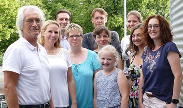 Foto von 9 Gründungsmitgliedern mit einem Kind