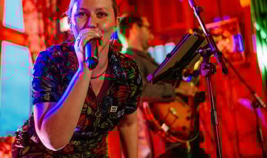 a woman in a floral dress singing into a microphone