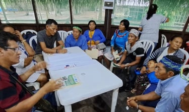 Indigenous community members gather around a table for a collaborative workshop and discussion.