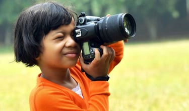 a young girl is taking a picture with a camera