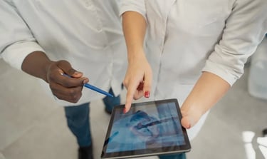 un médico con un bolígrafo y una Tablet enseñando una radiografía dental a otro odontólogo