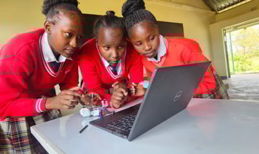 3 Kenyan girls in red sweaters building robots