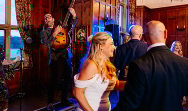 a man and woman playing guitar together in front of bride at wedding